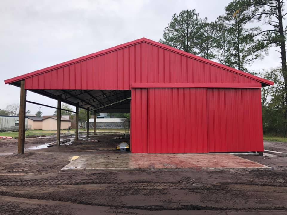 Red enclosed barn with lean-to extension