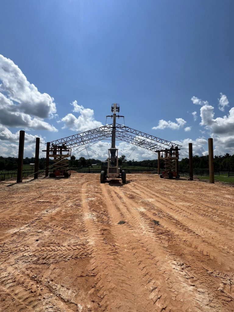 Steel trusses being erected on job site with crane
