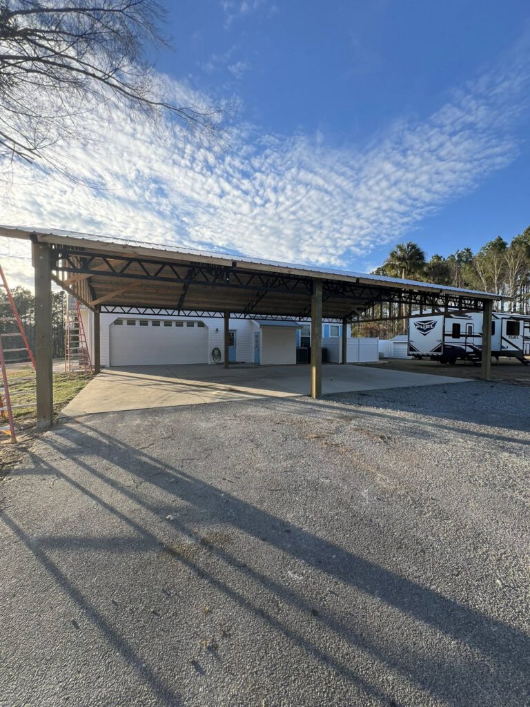 Finished pole barn with white garage doors and metal roof
